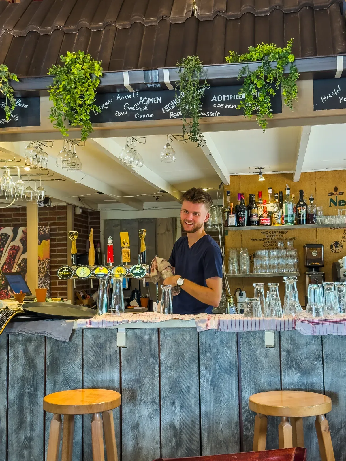 De barman achter de bar van Café-Restaurant De Heidehoeve